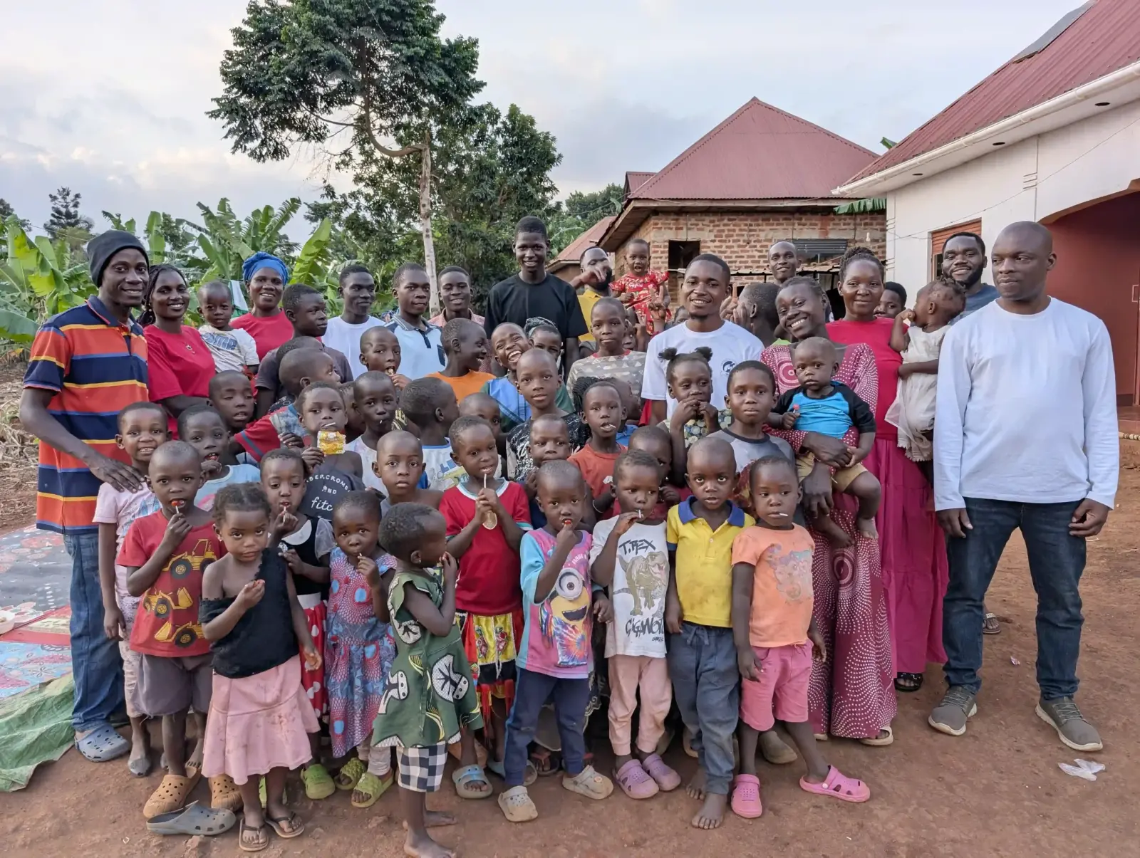 Children, staff and volunteers of Casita Orphans Foundation together in front of a house